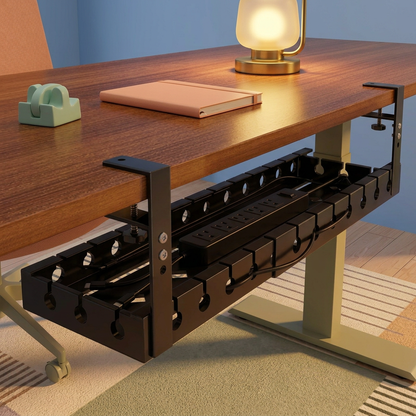 Black cable tray beneath a wood desk in a colorful evening workspace